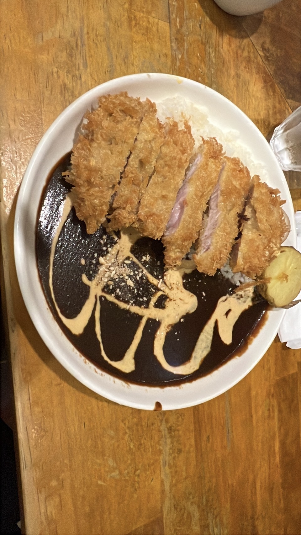 ロダンの特製ロースカツカレー。黒いルーにクリームの模様と大きなカツが盛られている